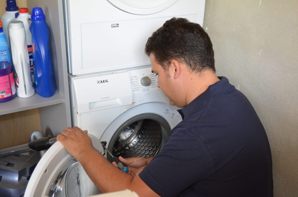 Técnico de Iluro Tecnic inspeccionando una lavadora averiada