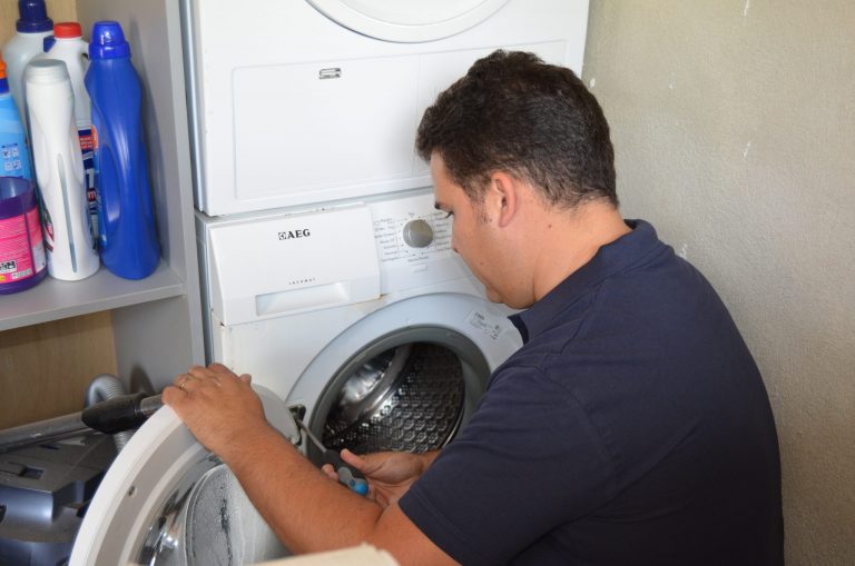 Técnico de Iluro Tecnic inspeccionando una lavadora averiada