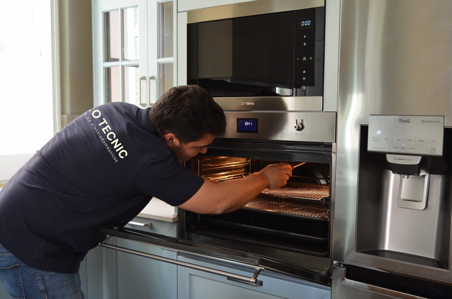 Técnico reparando horno, reparamos también neveras, microondas, congeladores, campanas extractoras, frigoríficos, lavadoras y secadoras de distintas marcas, como fagor, Bosch, Balay, Indesit, AEG, Zanussi y Siemens